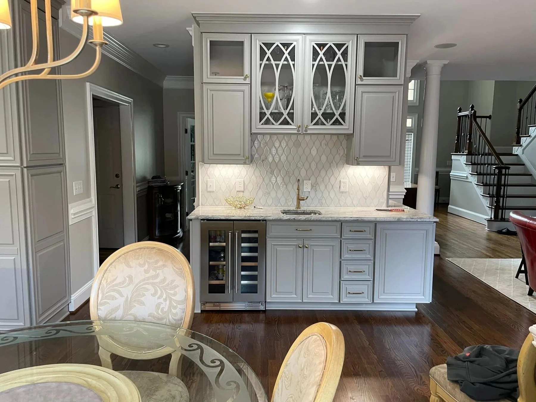 Grey built-in beverage station with glass door cabinets