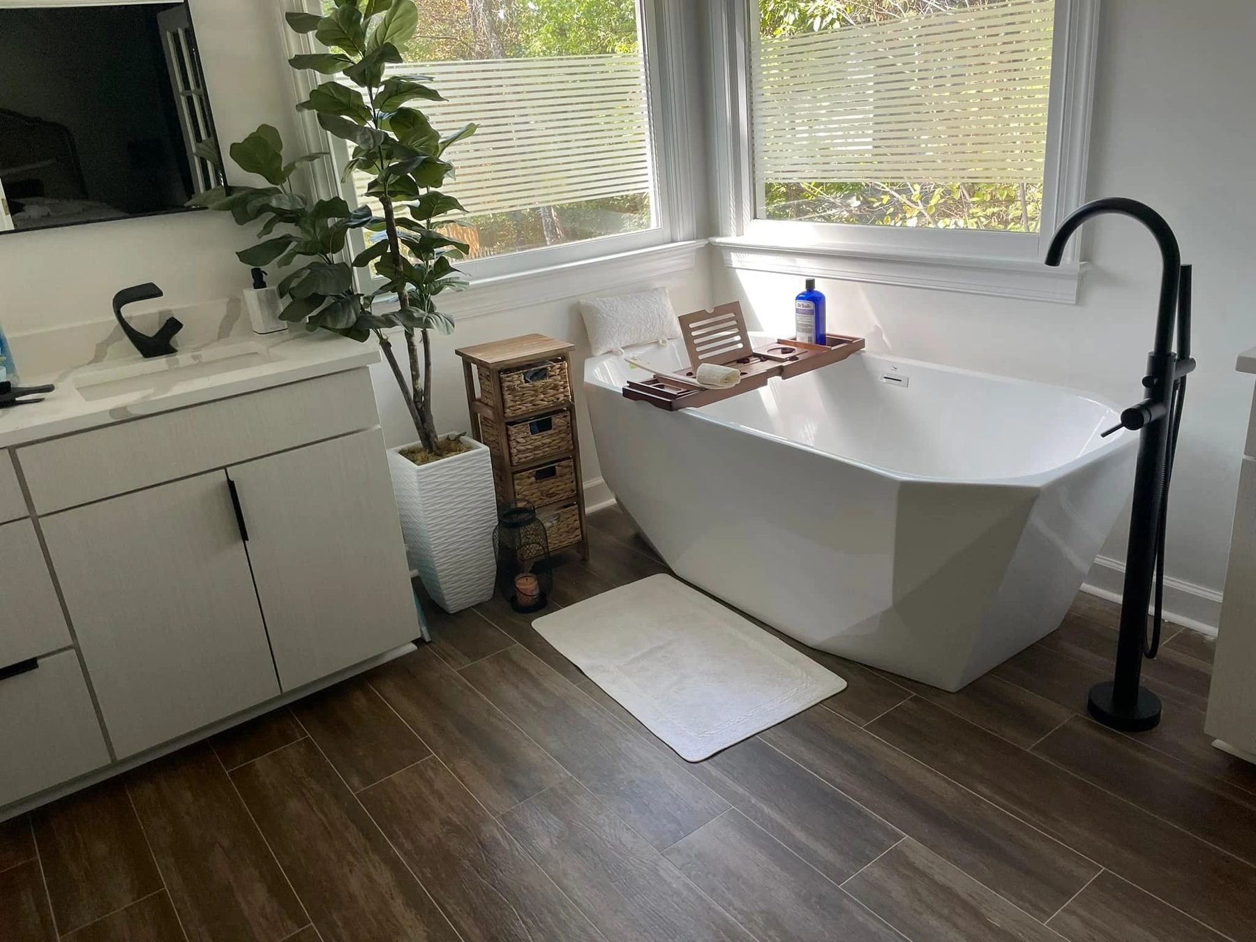 Bathroom with freestanding tub and matte black floor-mounted filler