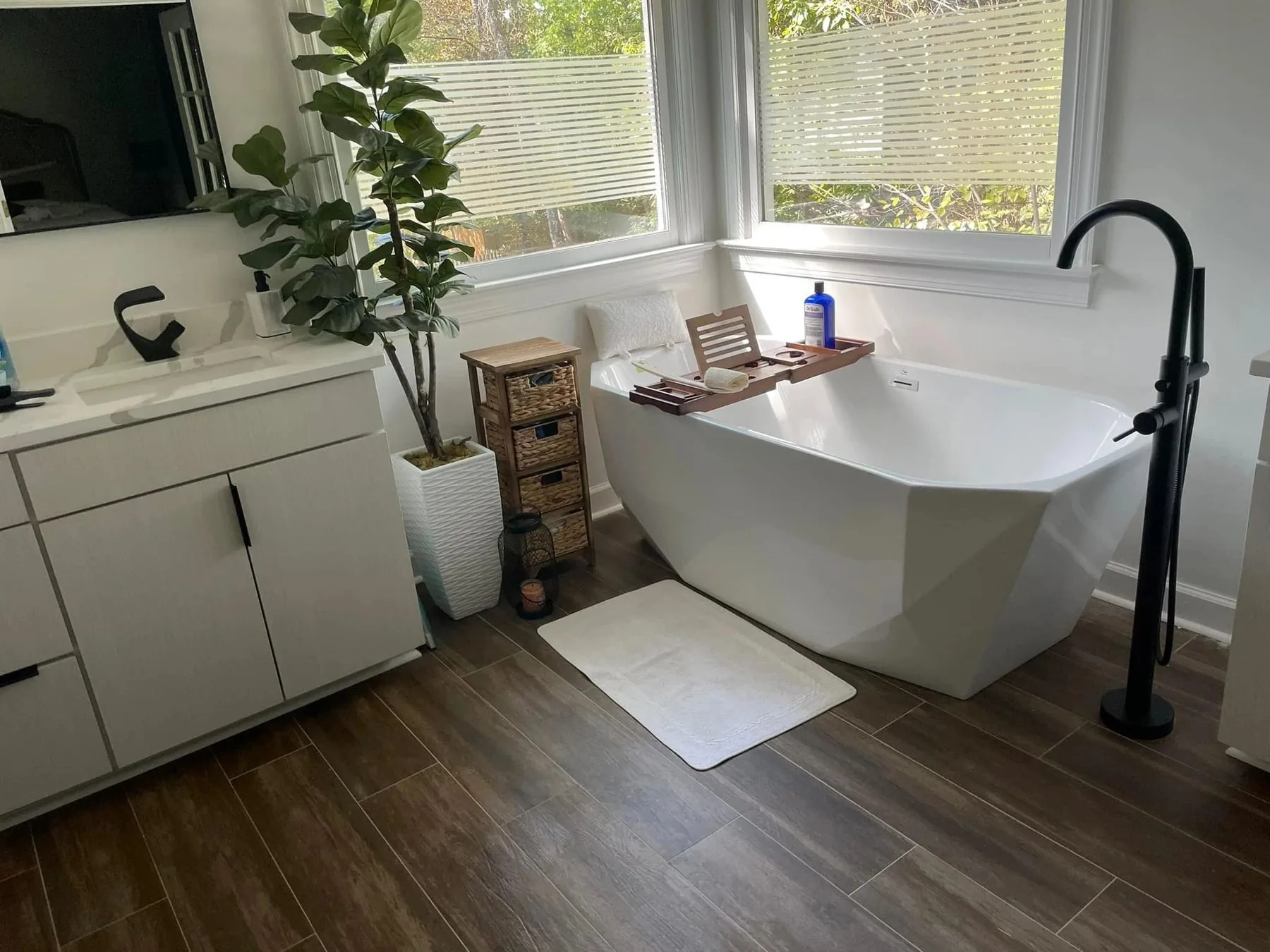 Bathroom with freestanding tub and matte black floor-mounted filler