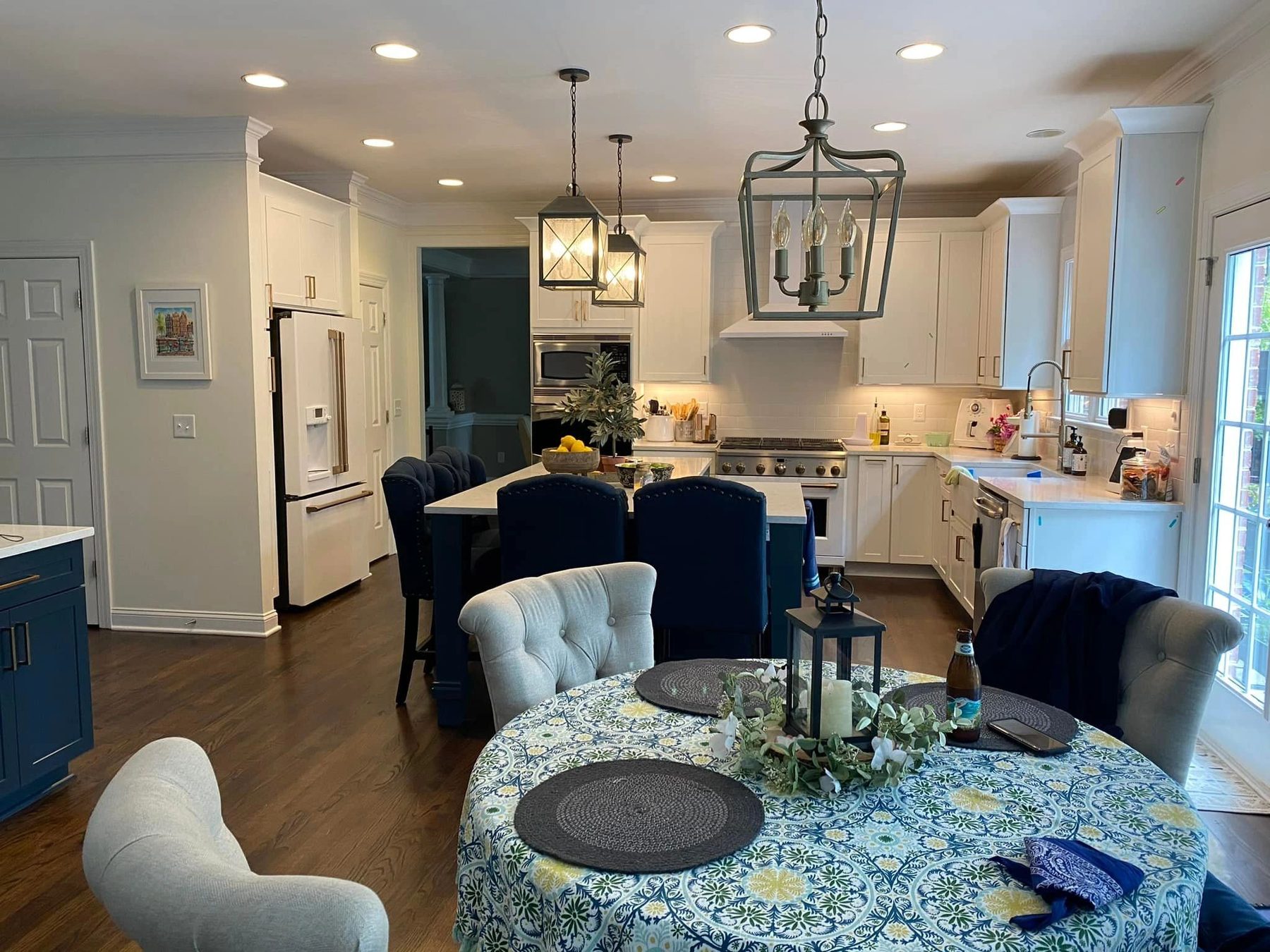 Kitchen with white cabinetry, lantern pendants, and taupe subway tile