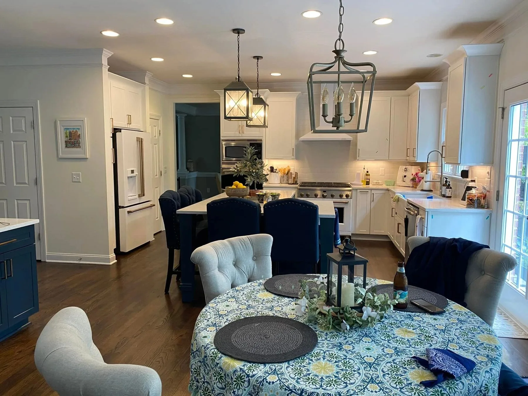 Kitchen with white cabinetry, lantern pendants, and taupe subway tile